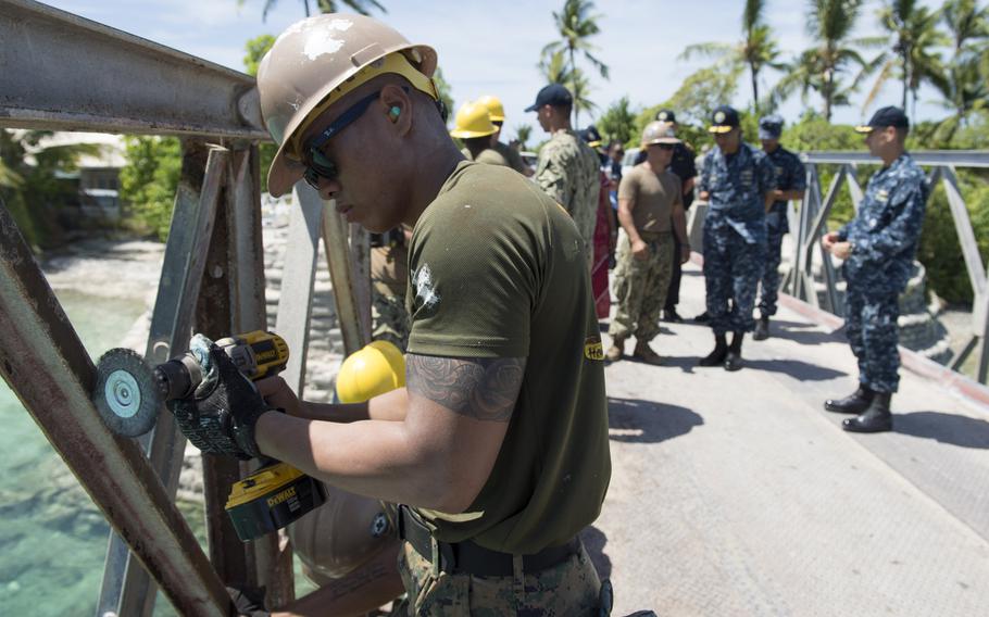 A U.S. Seabee removes rust from a bridge on Tarawa, Kiribati, during an engineering project that was part of Pacific Partnership 2013. U.S. Pacific Command is seeking to build stronger ties with nations that are vulnerable to the effects of climate change, such as Kiribati, by assisting them with infrastructure and security improvements.