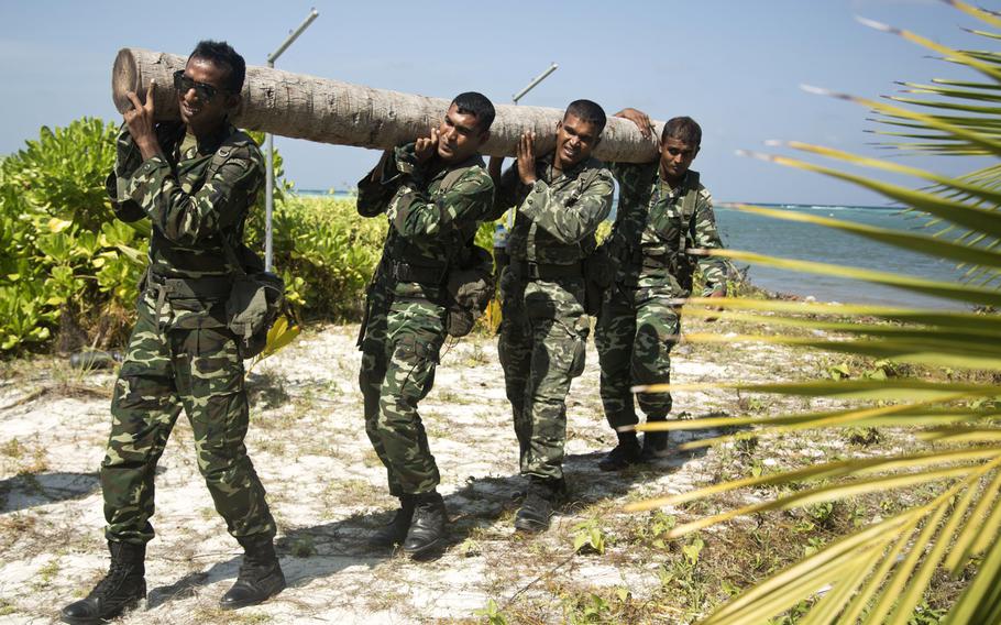 Maldivian Marines move logs to a training area to set up a squad competition during a non-commissioned officer development program with U.S. Marine Corps Forces on the Maldives on Jan. 21, 2014. The U.S. military is developing closer ties to the island nation by assisting it with environmental security issues arising from global climate change.