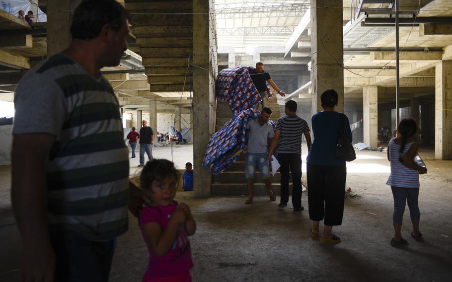 Displaced Iraqis find shelter in a sweltering unfinished building in Irbil, Iraq, Aug. 21, 2014. The Christians fled their homes in fear of the Islamic State's advance in the Mosul region.