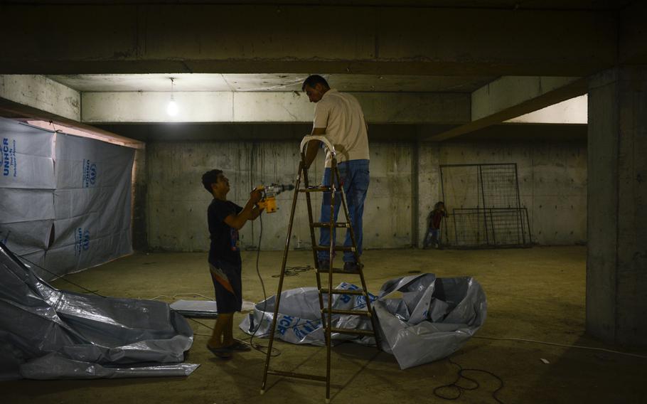 Displaced Iraqi Christians tarp off an area to serve as a makeshift school in the basement of an unfinished building in Irbil, Iraq, Aug. 21, 2014. The Christians fled their homes in fear of the Islamic State's advance in the Mosul region.