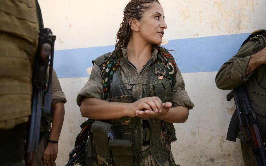 Zekia Karhan, 26, a female Kurdistan Workers' Party guerrilla from Turkey talks with some of her male counterparts in Makhmur, Iraq, Aug. 23, 2014.