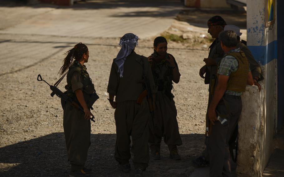 Zekia Karhan, 26, far-left, and Felice Budak, 24, third from left, visit with their a few of their male Kurdistan Workers' Party counterparts in Makhmur, Iraq, Aug. 23, 2014.