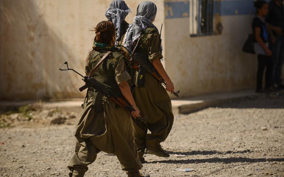 Zekia Karhan, 26, front-left, walks with two of her fellow Kurdistan Workers' Party female fighters in Makhmur, Iraq, Aug. 23, 2014.