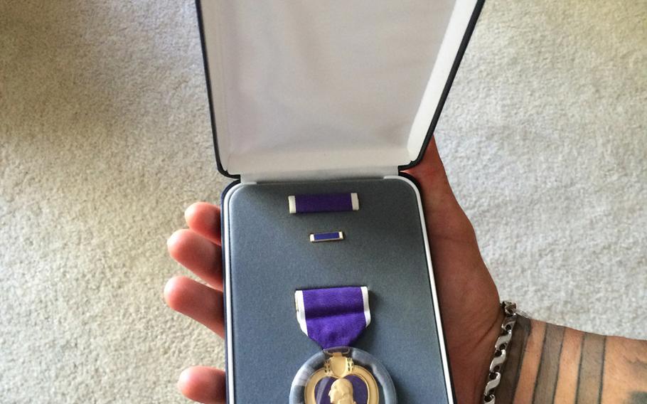 Professional wrestler Chris Melendez shows off the Purple Heart he was awarded after an IED took off his lower left leg in Iraq in 2006.