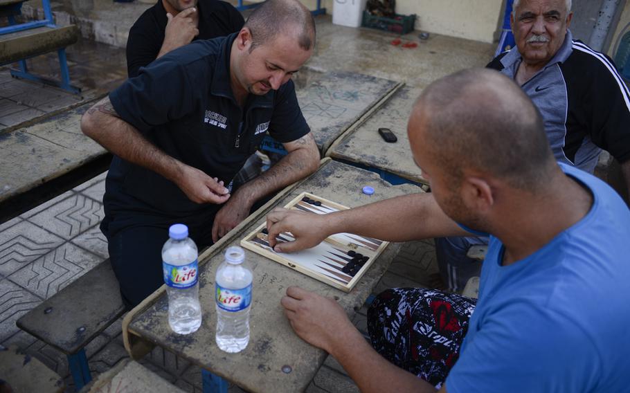 Displaced Yazidis play a board game backgammon in the school where they've been given shelter in the Ankawa district of Irbil, Iraq, Aug. 24, 2014. The Yazidis fled their homes in fear of advances by Islamic State militants.