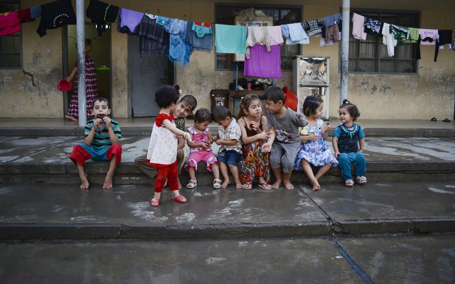 Displaced Yazidi children play in a courtyard of the school where they've been given shelter in the Ankawa district of Irbil, Iraq, Aug. 24, 2014. The Yazidis fled their homes in fear of Islamic State militant advances.