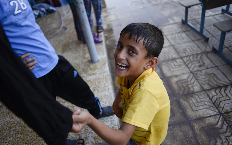 A displaced boy smiles for the camera in the school where he and other Yazidis have been given shelter in the Ankawa district of Irbil, Iraq, Aug. 24, 2014.