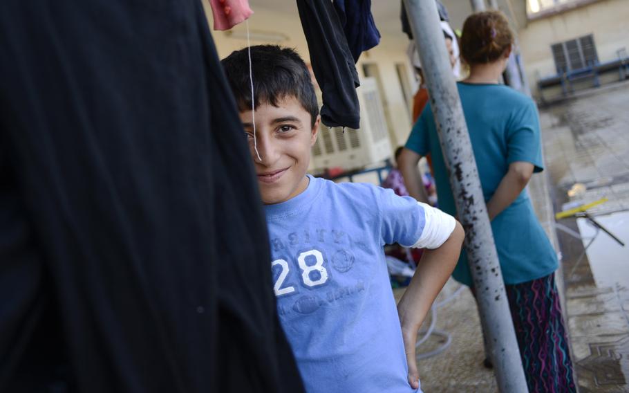 A displaced Yazidi boy smiles for the camera in a school in the Ankawa district of Irbil, Iraq, Aug. 24, 2014. The Yazidis fled their homes in fear of Islamic State militant advances.