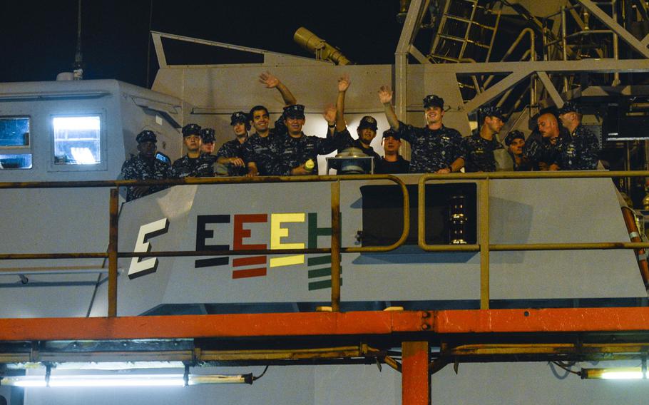 Sailors from the coastal patrol ships USS Hurricane and USS Monsoon wave to personnel on a pier after being transported by a yacht carrier vessel and arriving in Bahrain, Aug. 10, 2014. The Hurricane and Monsoon are the last two of 10 coastal patrol ships that are part of a realignment plan in the U.S. 5th Fleet area of responsibility.