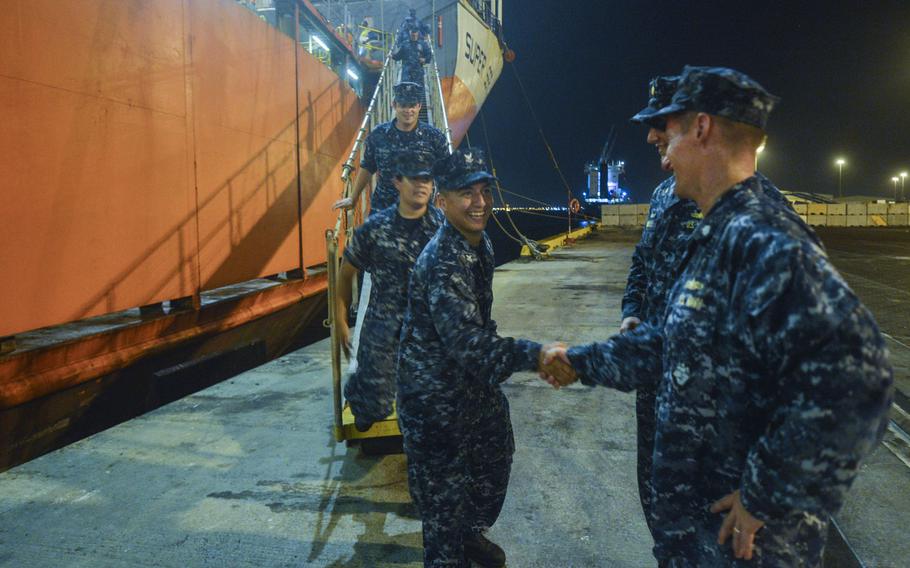 Sailors from the coastal patrol ships USS Hurricane and USS Monsoon shake hands with Cmdr. Thomas Shultz, commodore of Patrol Coastal Squadron 1, after disembarking from a yacht carrier vessel and arriving in Bahrain, Aug. 10, 2014. The Hurricane and Monsoon are the last two of 10 ships that are part of a realignment plan in the U.S. 5th Fleet area of responsibility.