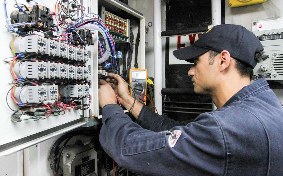 Petty Officer 1st Class Sher Butt, an interior communications technician aboard the USS Monsoon, fixes an alarm panel in engineering, Aug 28, 2014. The Monsoon and the USS Hurricane, which arrived in Bahrain on Aug. 13, are undergoing a reactivation process at their new homeport.