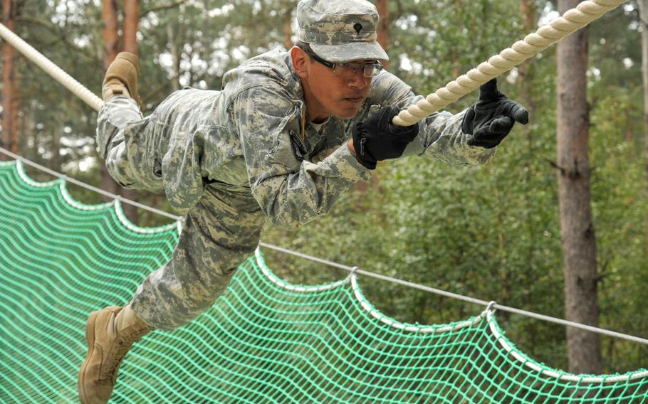 U.S. Army Spc. Michael Merino, with Headquarters and Headquarters Company, 18th Combat Sustainment Support Battalion, negotiates a rope obstacle at the 7th Army Joint Multinational Training Command's Grafenwoehr Training Area, Germany, Sept. 4, 2014.