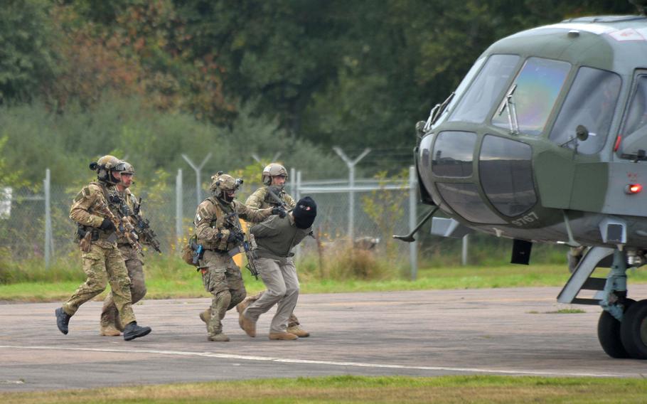 Special operations forces take a captured "terrorist" to a waiting helicopter during a demonstration at Jackal Stone 14, an exercise hosted by the U.S. Special Operations Command Europe at Baumholder, Germany, Friday, Sept. 12, 2014. Forces from 10 nations are taking part in the event in numerous locations in Germany and the Netherlands.