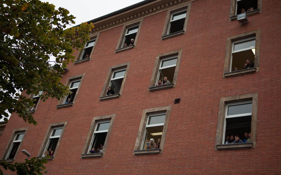 German civilians who work for the U.S. Army in Bamberg crowd the windows of one of the garrison's buildings to watch a closing ceremony Friday, Sept. 12, 2014, marking the end of the Army's presence here.