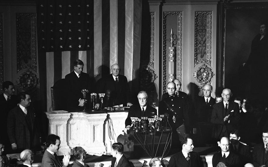Declaring Japan guilty of a dastardly unprovoked attack, President Franklin D. Roosevelt asked Congress to declare war, Dec. 8, 1941. Listening are Vice President Henry Wallace, left, and House Speaker Sam Rayburn.