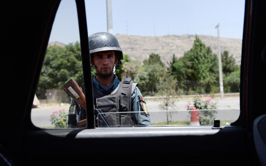 An Afghan uniformed policeman mans an election day checkpoint along the highway between Kabul and Wardak province during the runoff presidential vote on June 14, 2014. Police officials are once again preparing for violence as the government is poised to announce the election results.