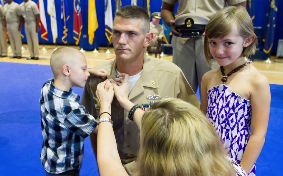 Chief Petty Officer Kristopher Griffin is pinned by his family at a chief pinning ceremony at Naval Support Activity Bahrain on Tuesday, Sept 16,2014. He was one of 55 chiefs pinned at NSA Bahrain.