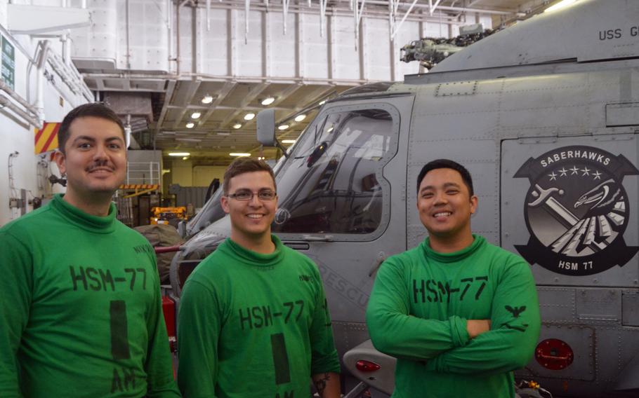 From left, helicopter maintainers Petty Officer 2nd Class Justin Nixon, Petty Officer 3rd Class Michael Moore and Petty Officer 2nd Class Jeremiah Malicsi take a break after working on their MH-60R helicopter aboard the USS George Washington on Wednesday. The crew is participating in the Valiant Shield exercise off the Guam coast.