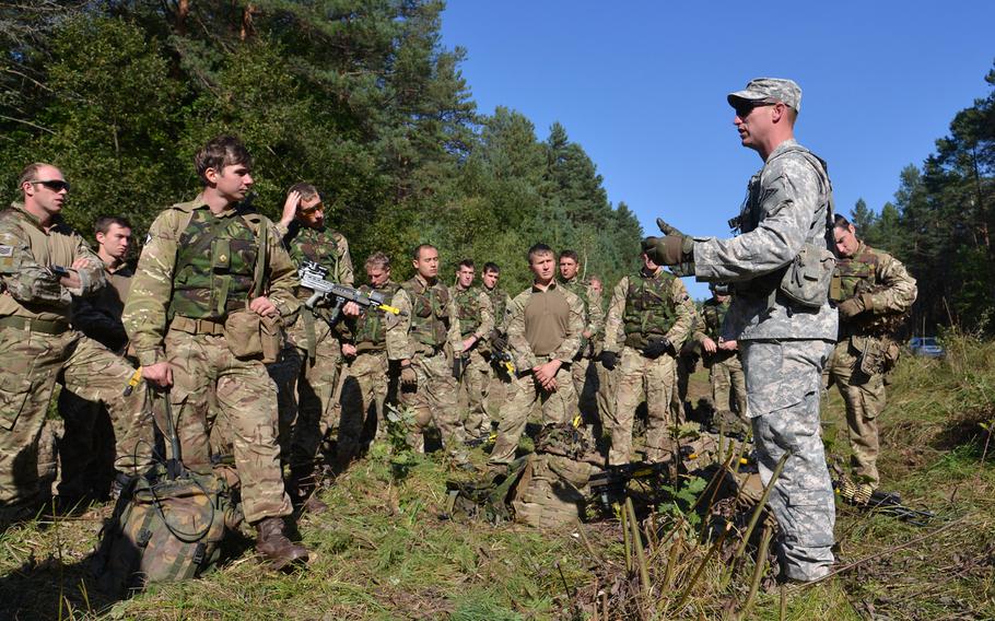 Sgt. 1st Class Josh Ward of the Joint Multinational Readiness Center discusses with British soldiers things done right and wrong during convoy training at Exercise Rapid Trident near Yavoriv, Ukraine, Wednesday, Sept. 17, 2014.