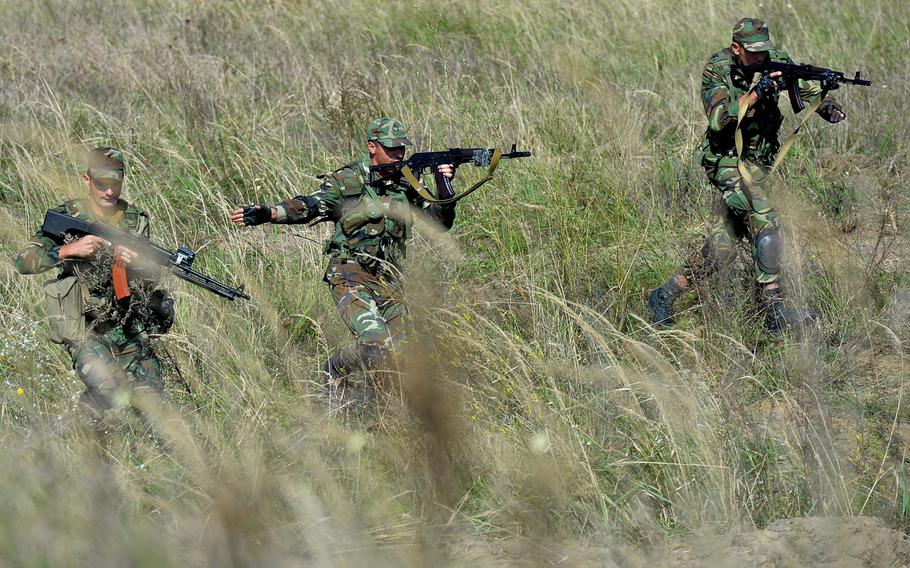 Soldiers from Azerbaijan make their way through tall brush as they go through patrol training during Exercise Rapid Trident near Yavoriv, Ukraine, Wednesday, Sept. 17, 2014. The exercise runs through Sept. 26.