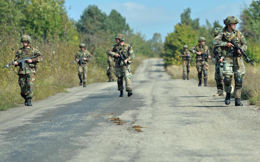 Romanian soldiers patrol a road during Exercise Rapid Trident near Yavoriv, Ukraine, Thursday, Sept. 18, 2014. The U.S., Ukraine and 13 other nations are taking part in the exercise.