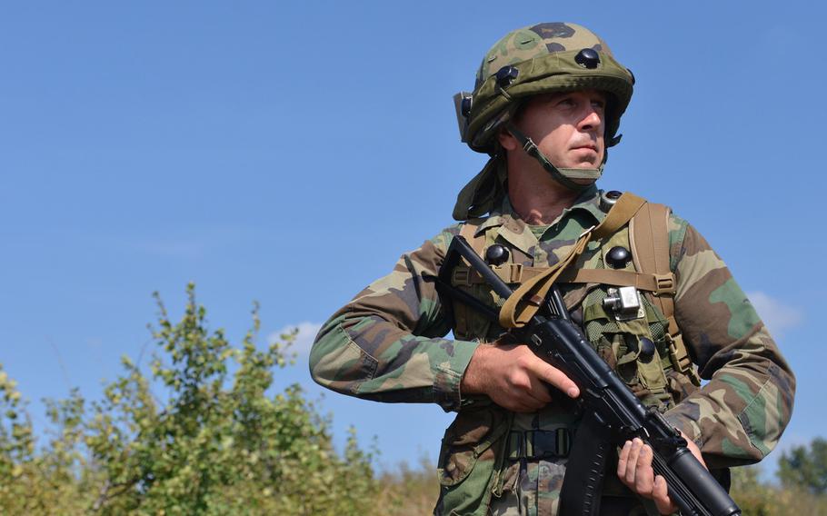 A Romanian soldier patrols a road during training at Exercise Rapid Trident near Yavoriv, Ukraine, Wednesday, Sept. 17, 2014.