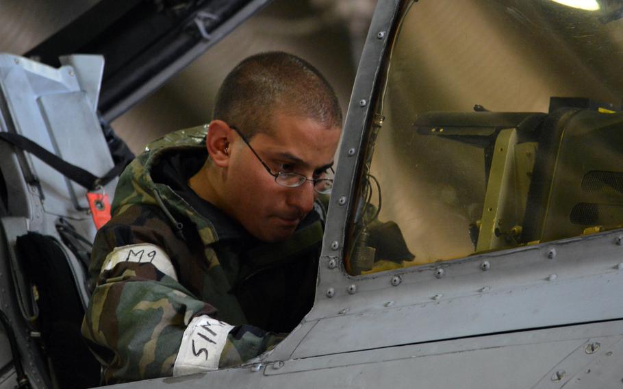 An Air Force airman maintenance crewmember performs maintenance inside an A-10 Thunderbolt II cockpit during the Beverly Bulldog 14-04 exercise at Osan Air Base, South Korea, on Sept. 18, 2014. Airmen with 25th Fighter Squadron worked 12-hour shifts to keep their aircraft going during the exercise.