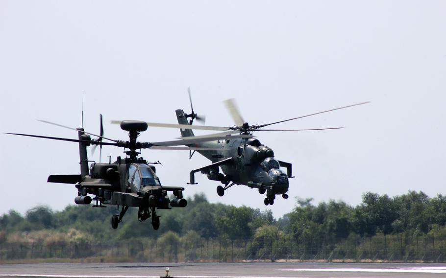 An AH-64E Apache Guardian from the 25th Infantry Division, and a Mi-35 Attack Helicopter from 31st Squadron, Tentara Nasional Indonesia Angkatan Darat, take off for a flight together during an attack/reconnaissance training mission in Semarang, Indonesia, Sept. 9, 2014.
