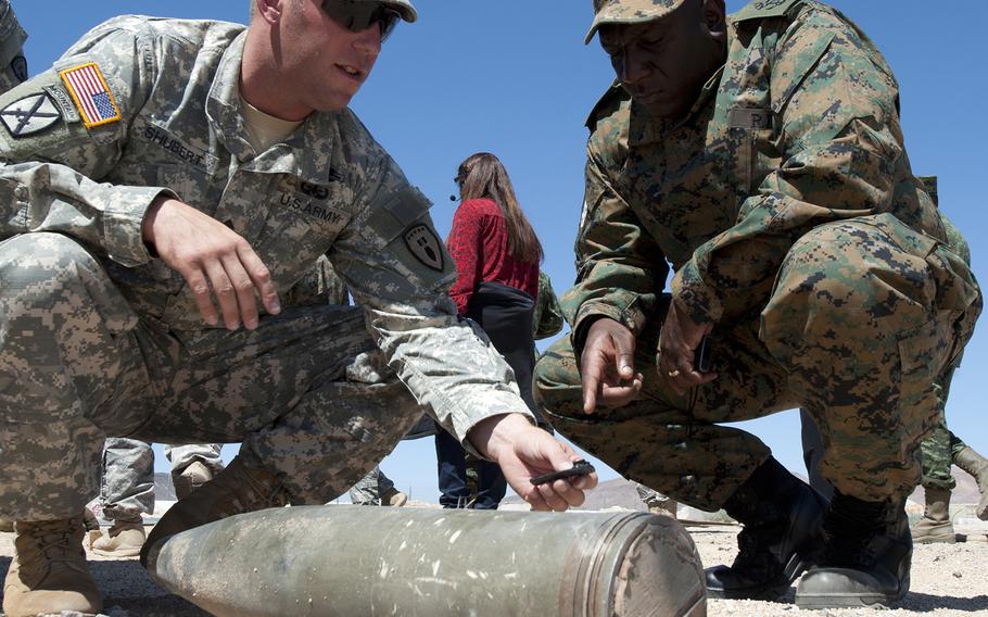 Staff Sgt. Stephen Shubert, EOD team leader, and Royal Bahamas Defense Force Leading Seaman Malford Ingraham discuss the results of an EOD training exercise, on Sept. 9, 2014.