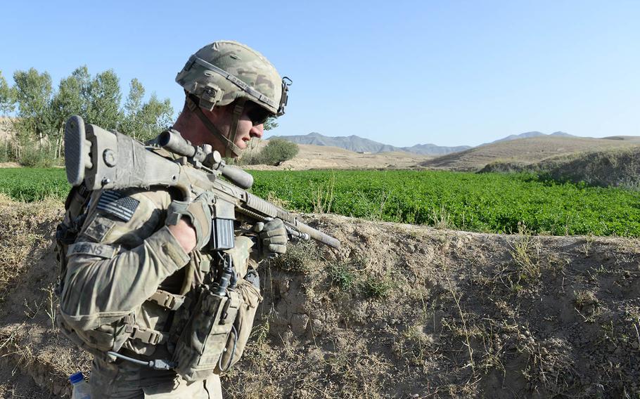 Sgt, Jonathon Burns, a sniper with "Dragon Platoon," 2nd Squadron, 3rd Cavalry Regiment moves into a village after a firefight with Taliban fighters subsides on Monday,, Sept. 15, 2014, in Logar province, Afghanistan.