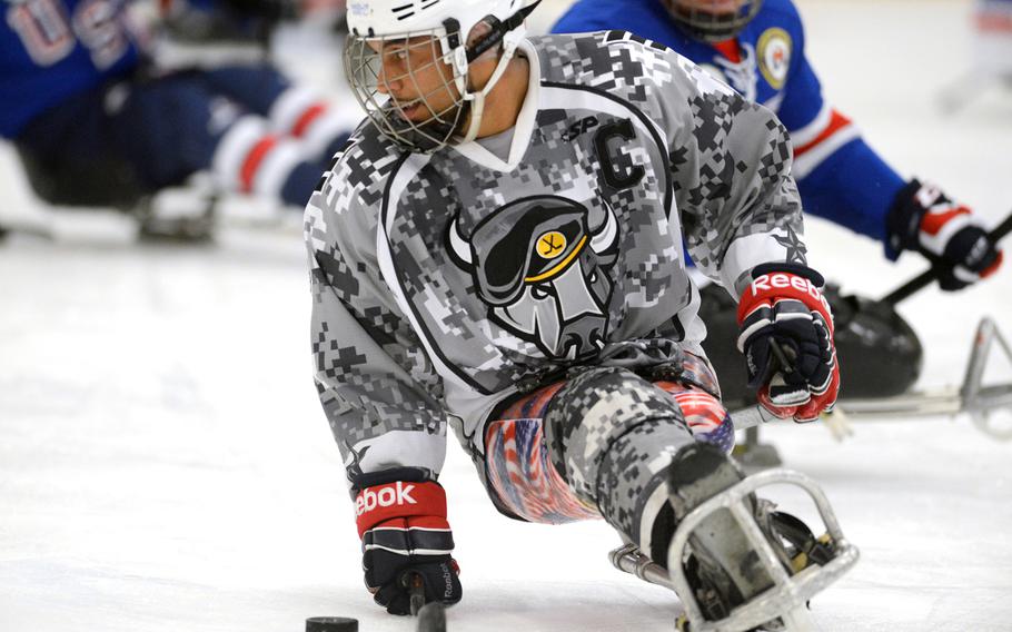 Army veteran Rico Roman of the San Antonio Rampage handles a puck during a sled hockey game with the USA Warriors in Rockville, Md., Sept. 18, 2014.