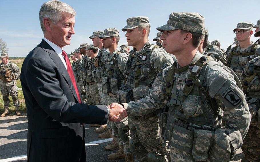 Secretary of the United States Army John McHugh shakes hands with Pvt. Garret Matthews, a paratrooper with the U.S. Army Europe's 173rd Airborne Brigade, while talking to soldiers at Rapid Trident 2014 in the Ukraine, Sept. 19, 2014.