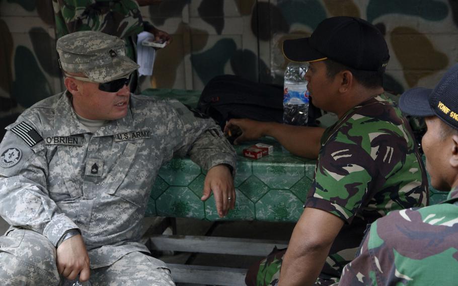 Sgt. First Class Patrick O'Brien, with 2nd Battalion, 1st Infantry Regiment, from Joint Base Lewis-McChord, chats with a new friend from the Indonesian army during a break at a makeshift canteen during Garuda Shield in Indonesia.