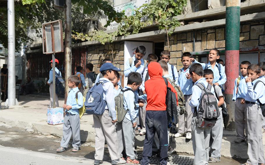 Afghan school children gather around the site of a magnetic bomb attack that injured the driver of an Afghan military vehicle outside the presidential palace in Kabul, on Sunday, Sept. 28, 2014. The blast sparked concerns that insurgents would try to disrupt Monday's swearing-in ceremony for Ashraf Ghani, Afghanistan's new president.