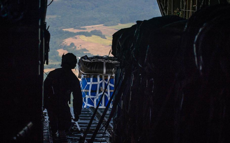Senior Airman Cody Olson, 39th Airlift Squadron loadmaster, watches as cargo exits the back of a 37th AS C-130J Super Hercules over Germany, on June 18, 2014.