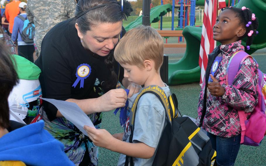 Aukamm Elementary School teacher Michelle House pins a 2014 Blue Ribbon to her first grade student Ethan Wineberner at a celebration Wednesday, Oct. 1, 2014, recognizing Aukamm Elementary as a 2014 Department of Education Blue Ribbon School.