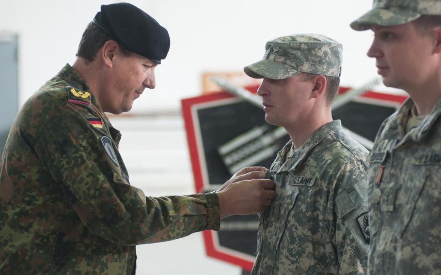 German Brig. Gen. Markus Laubenthal, the U.S. Army Europe chief of staff, presents Chief Warrant Officer 2 Michael James with the German Medal for Flood Relief 2013, during a Feb. 24, 2015 ceremony.