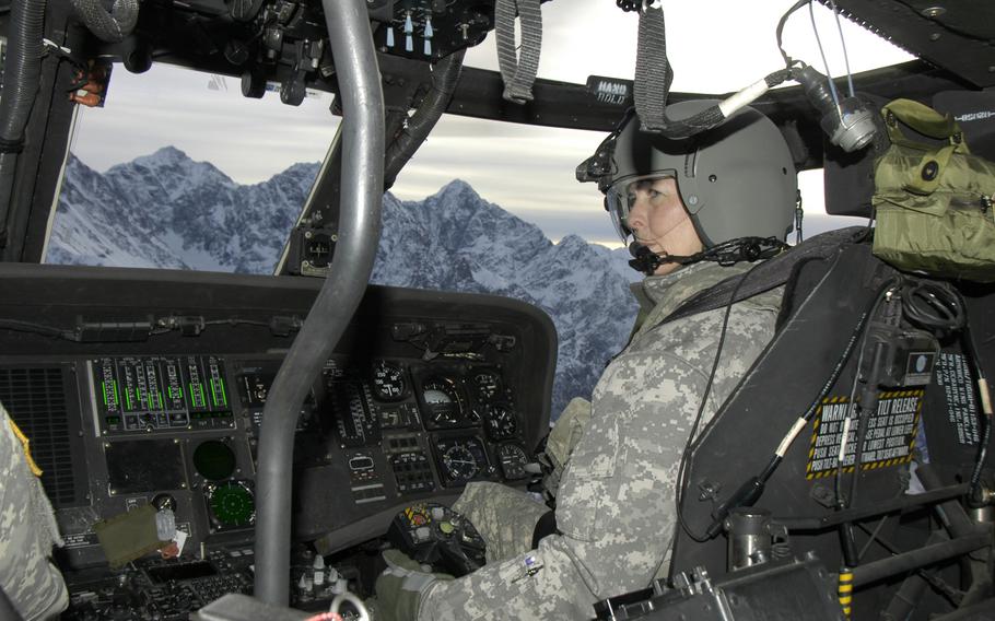 Alaska Army National Guard Chief Warrant Officer 4 Pamela Vitt guides a UH-60 Black Hawk helicopter over mountains near Anchorage on Feb. 13, 2015. Pilots and other crewmembers take part in cold-weather survival training in case they are forced to make an emergency landing in the Alaska wilderness. 