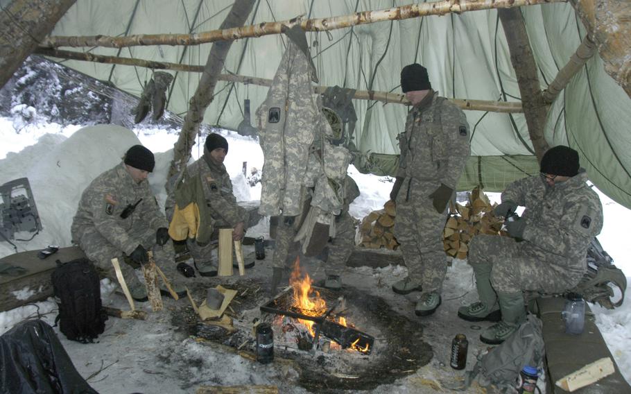 Army aviators stay warm during Arctic survival training in Alaska on Feb. 10, 2015. The soldiers huddled together for warmth around a large, comforting blaze under a parachute that kept snow flurries from their heads.


Seth Robson/Stars and Stripes