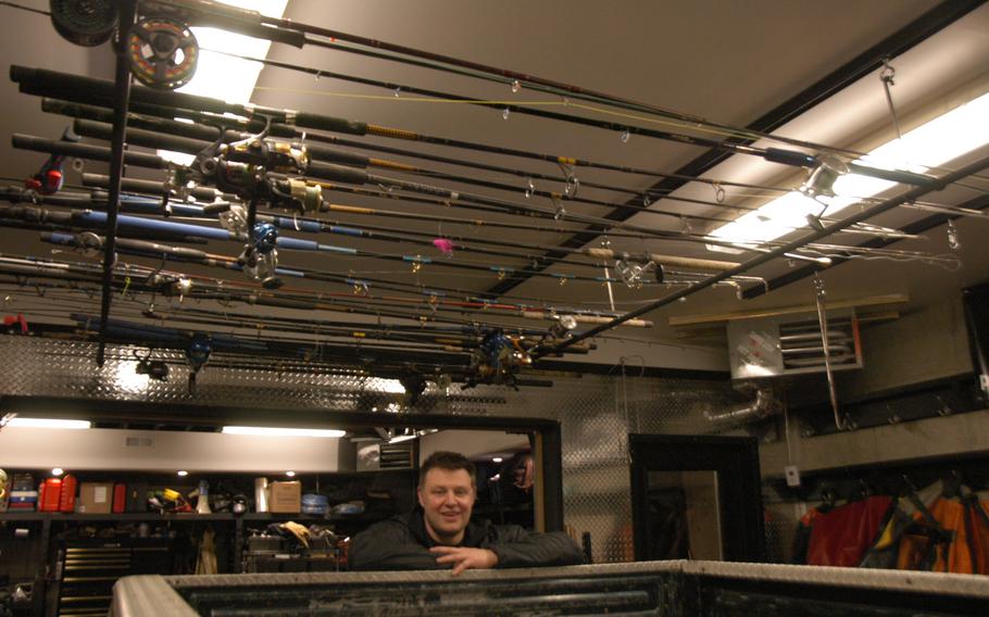 Anchorage businessman Justin Green hangs his fishing rods from the ceiling of his garage. Fishing is one of the most popular sports in the 49th state.
