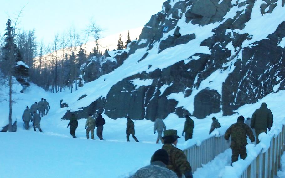 U.S. and foreign troops hike past rock outcrops used to teach military mountaineering at the Black Rapid Training Site, Alaska, in February 2015.