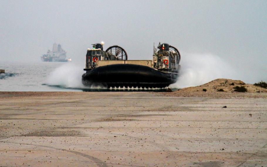 A landing craft air-cushioned transport arrives at a landing area in Kuwait to take Marines and equipment from the 24th Marine Expeditionary Unit back to the USS New York, seen in the background, after the Marines spent a month training in the country. The ship and its embarked Marines are on an eight-month deployment to the U.S. 5th Fleet area of responsibility as part of the Iwo Jima amphibious ready group.