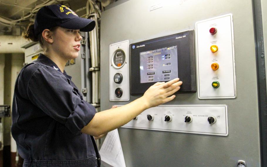 Petty Officer 3rd Class Allison Hodge, a machinist's mate aboard the USS New York, operates a touch screen panel that controls one of the ship's diesel engines.