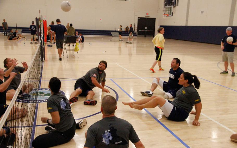 Athletes practice 'seated' volleyball at Joint Base Pearl Harbor-Hickam, Hawaii, during team trials by Navy Wounded Warrior-Safe Harbor for the multi-service Warrior Games competition to be held June 19-30, 2015.