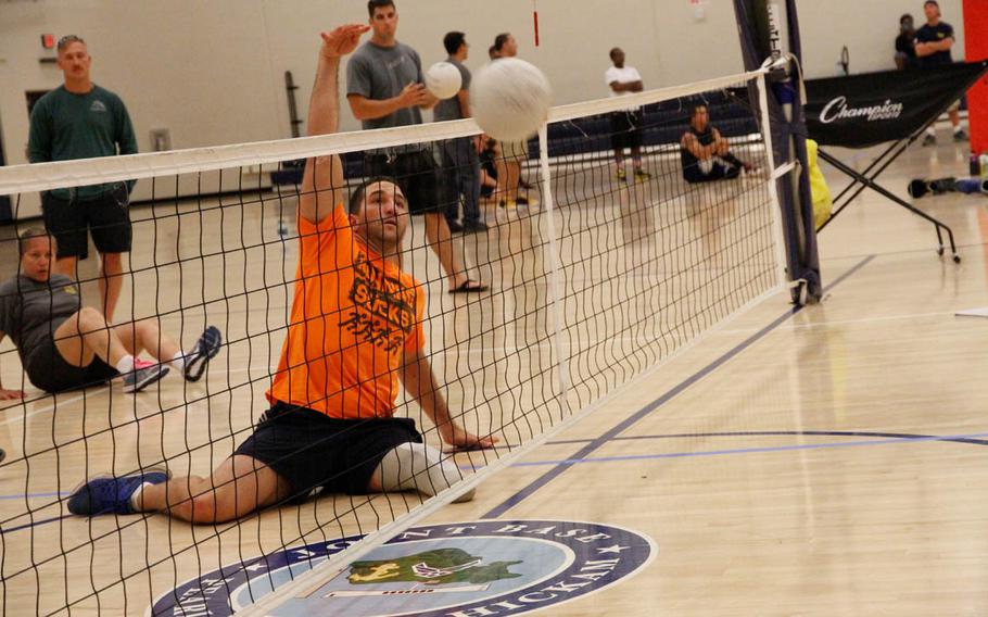 Redmond Ramos, a former Navy corpsman attached with the Marines, spikes a ball over the net during try-outs for 'seated' volleyball at the gym at Joint Base Pearl Harbor-Hickam, Hawaii, on Monday, March 9, 2015. Selected athletes will compete in June at the Warrior Games.