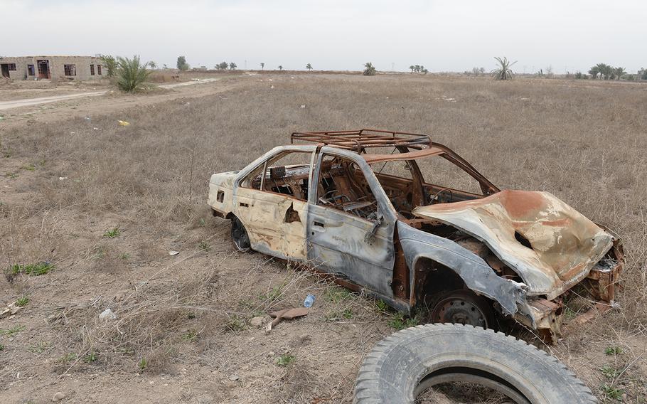 The remnants of a car bomb lie by the roadside near Karmah, Iraq, March 12, 2015. The Islamic State stronghold of Fallujah is less than 10 miles away.