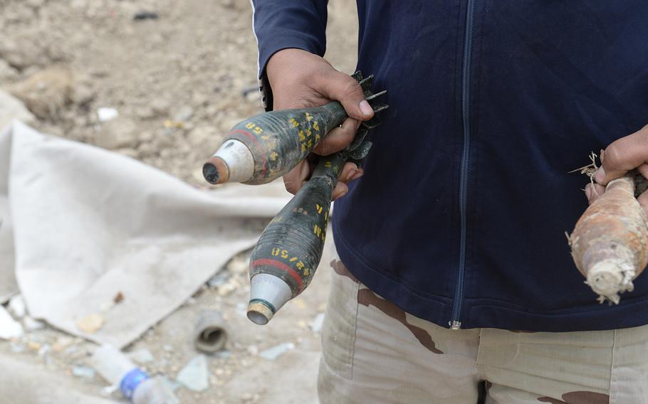 An Iraqi soldiers holds live mortar rounds that were part of an improvised explosive device in Karmah, Iraq, March 12, 2015. Commanders say there are too many such explosives and too few engineers to properly dispose of them.