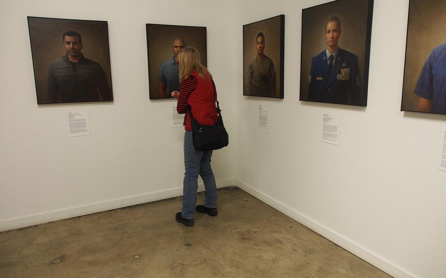 A woman looks at the "100 Faces of War Experience" at the National Veterans Art Museum in Chicago. The museum, founded by Vietnam veterans, is increasingly getting art from troops who served in Iraq and Afghanistan.