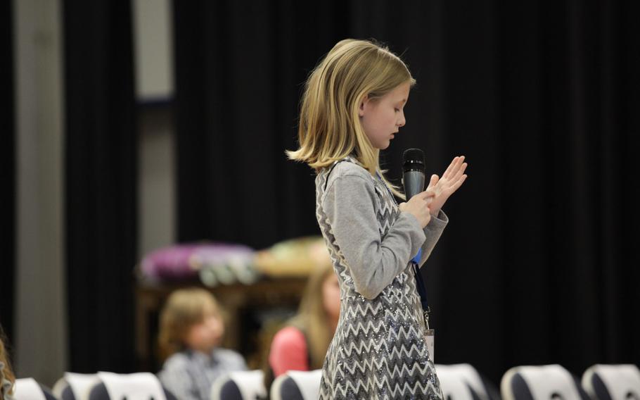 Ava Collins, representing Landstuhl Elementary-Middle School writes out a word on her hand before giving her answer Saturday, March 21, 2015, at the European PTA Spelling Bee at Ramstein Elementary School in Germany.