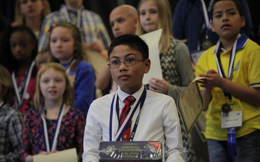 Naples sixth-grader Ryan Rayos holds a dictionary after winning the European PTA Spelling Bee Saturday, March 21, 2015, at at Ramstein Elementary School in Germany.